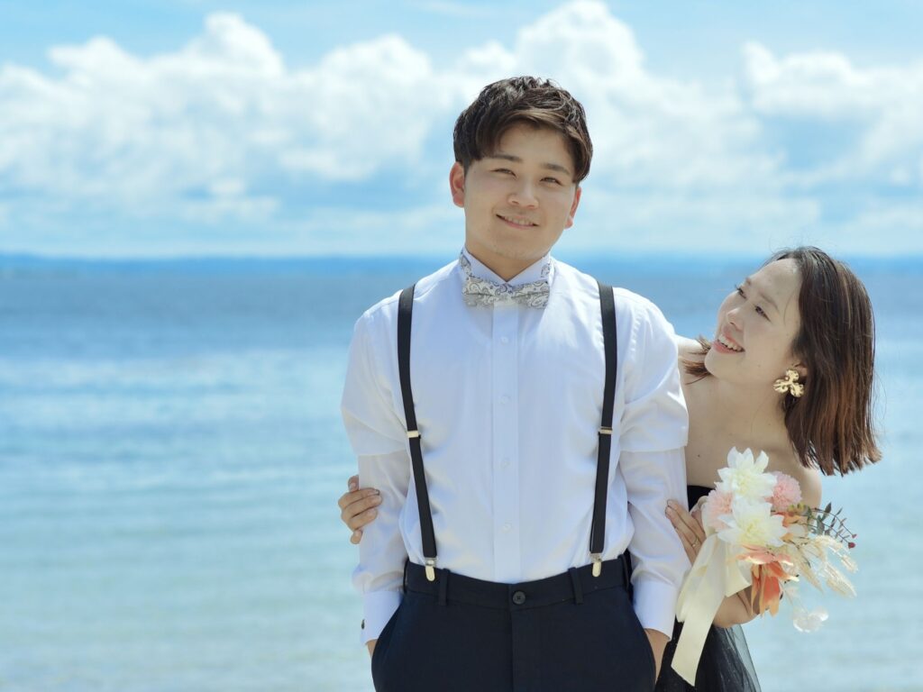 新郎の後ろから抱きつき笑顔を見せる花嫁の前撮り写真